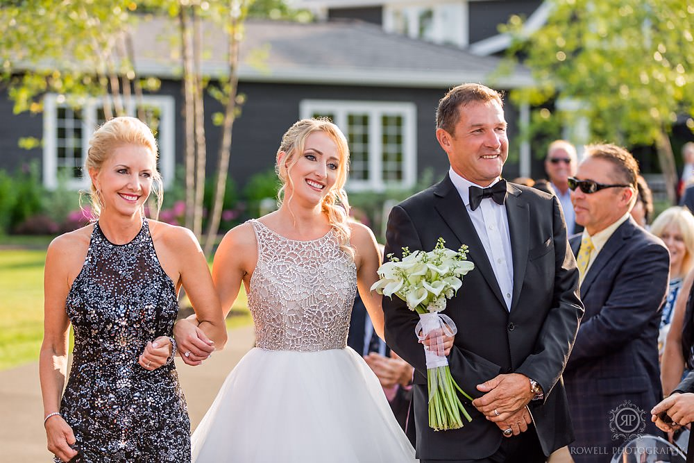 a romantic backyard wedding bride and parents walking down aisle